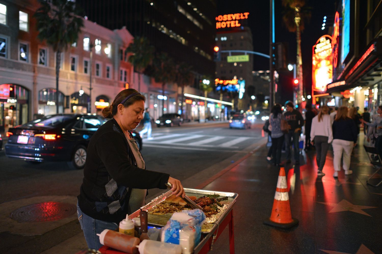 Maria Navas prepares hot dogs in front of the Dolby Theatre on the Hollywood Walk of Fame, in Los Angeles, on March 18, 2019. - Navas arrived to the United States from Mexico City, 