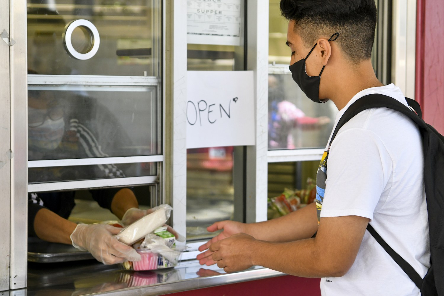 A returning student receives pre-packaged lunch at Hollywood High School on April 27, 2021 in Los Angeles, California.
