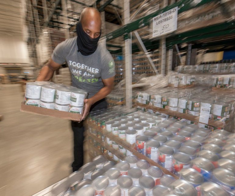 A employee stacks cans at the Greater Chicago Food Depository 102621