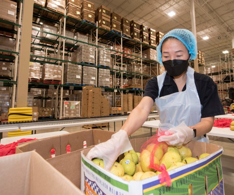 Volunteer Eliza Chu of Chicago bags up pears at the Greater Chicago Food Depository 102621