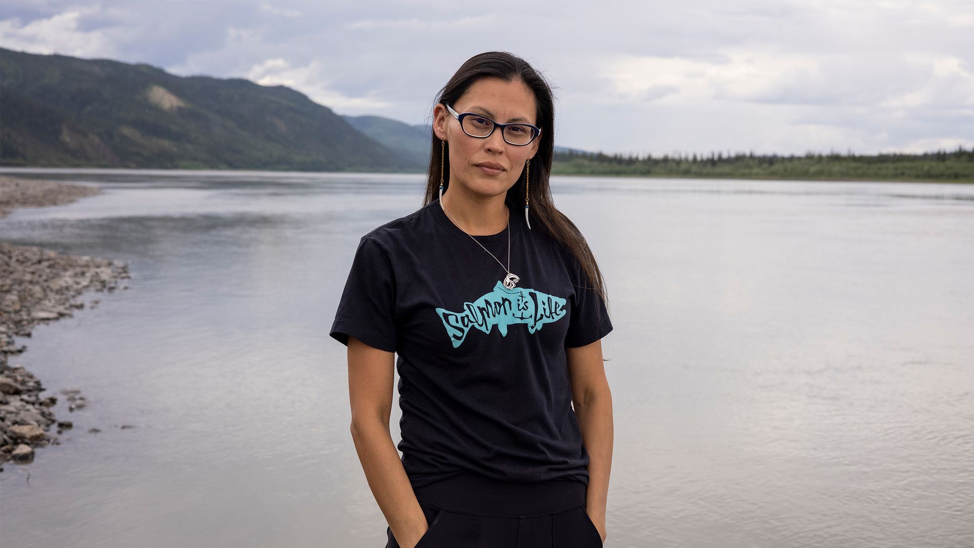 Women with black salmon is life t shirt looking into camera with body of water behind November 2021.