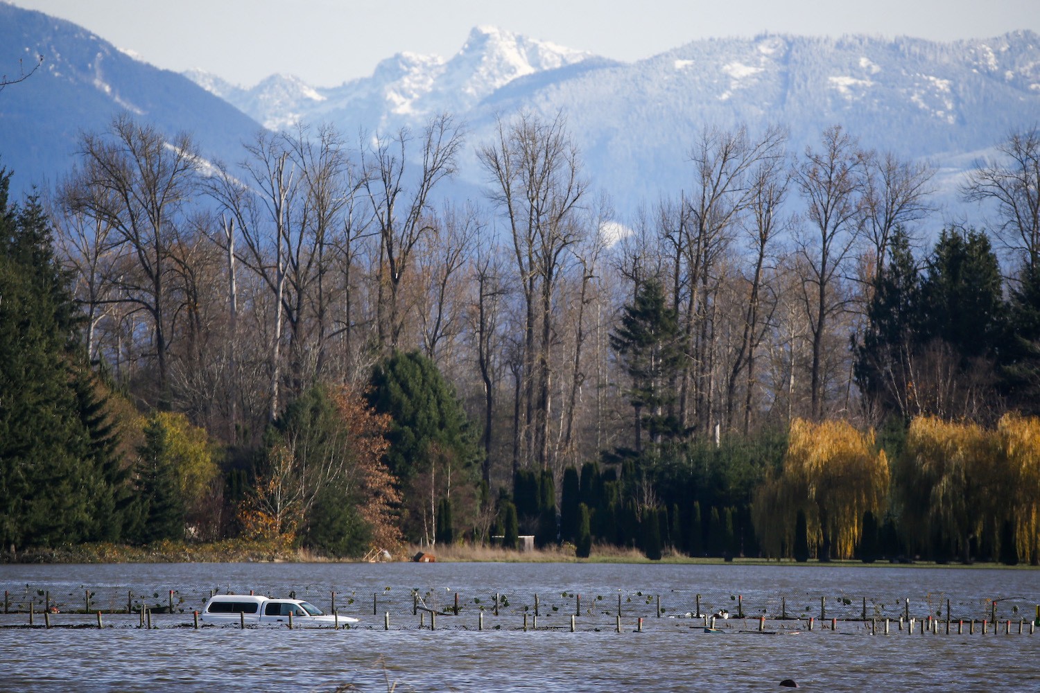 A car is seen partially submerged as floodwaters from the Skagit River inundate farmland outside of Burlington, Washington, on November 17, 2021.