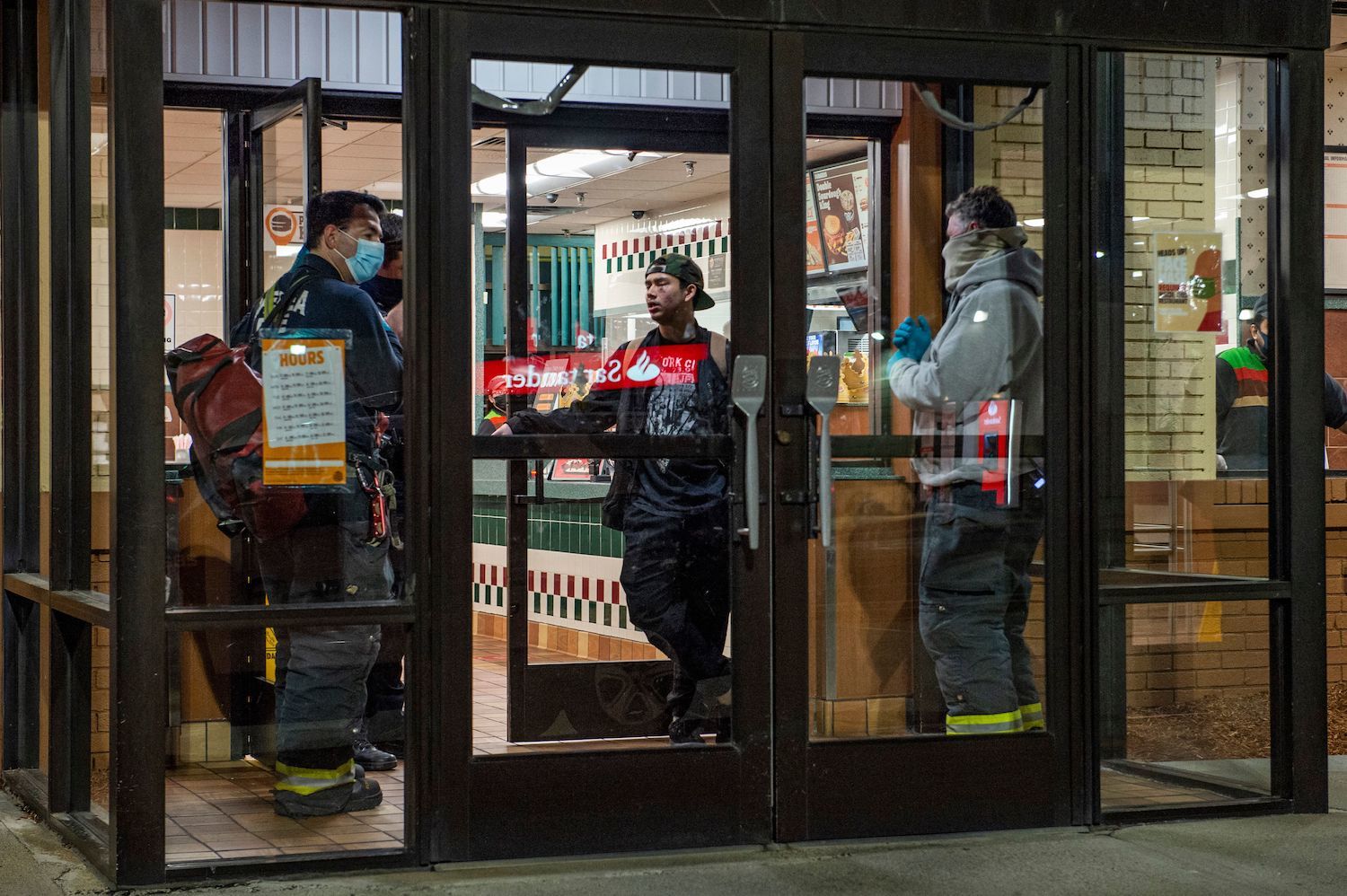 Officers speak to a Burger King employee that was punched in the face by an angry customer, asking him questions to find out more about what happened and if he needed medical attention in Chelsea, Massachusetts on May 1, 2021.