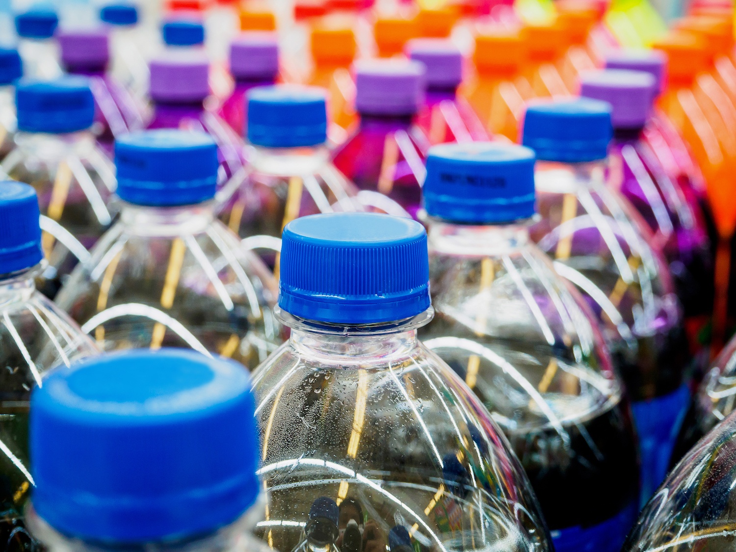 Tops of plastic soda bottles stored in supermarket. December 2021