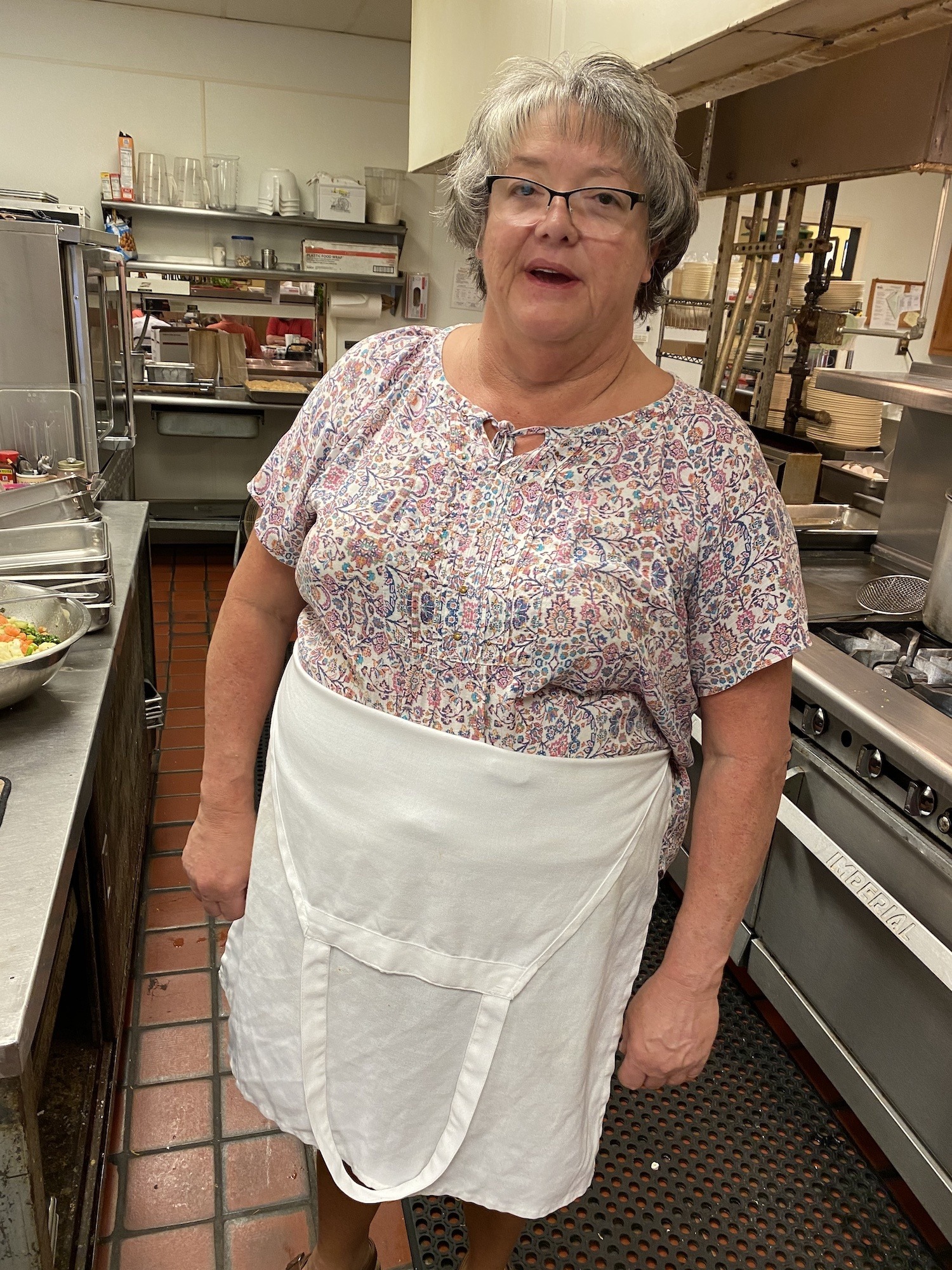 Jackie Sinclair, owner of Ila Restaurant, stands with an apron in the kitchen. January 2022