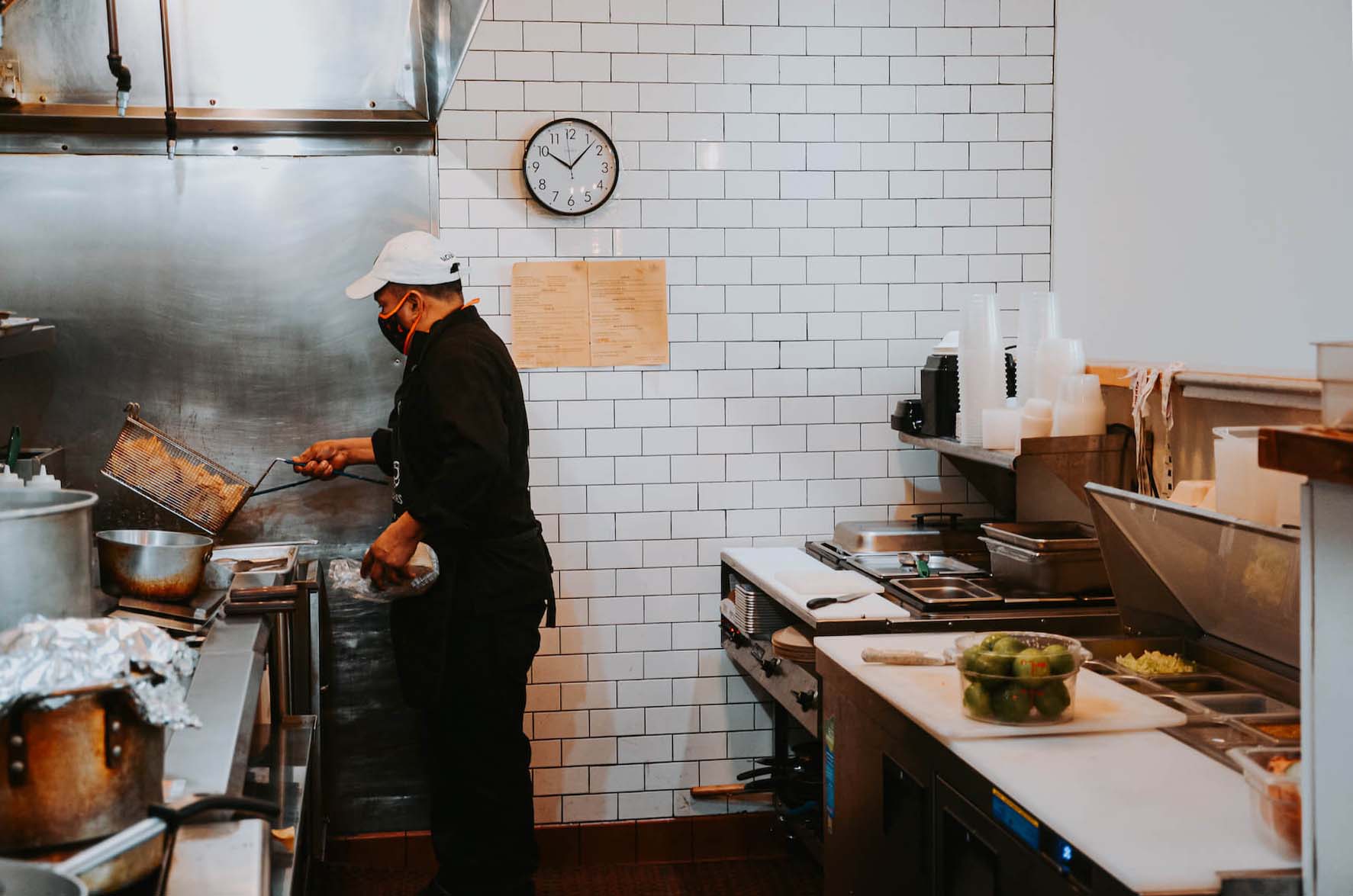 Luis Maldonado prepares chips in fryer in La Guerrera's Kitchen in Oakland, CA. August 2021