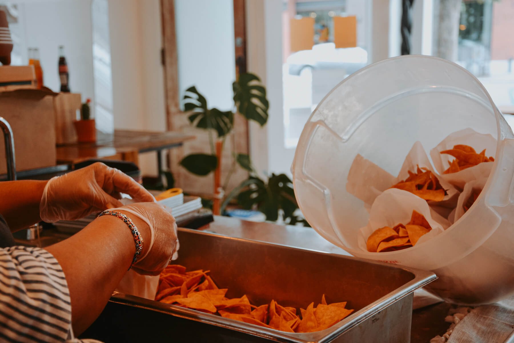Ofelia Barajas bags chips at La Guerrera's Kitchen in Oakland, CA. August 2021