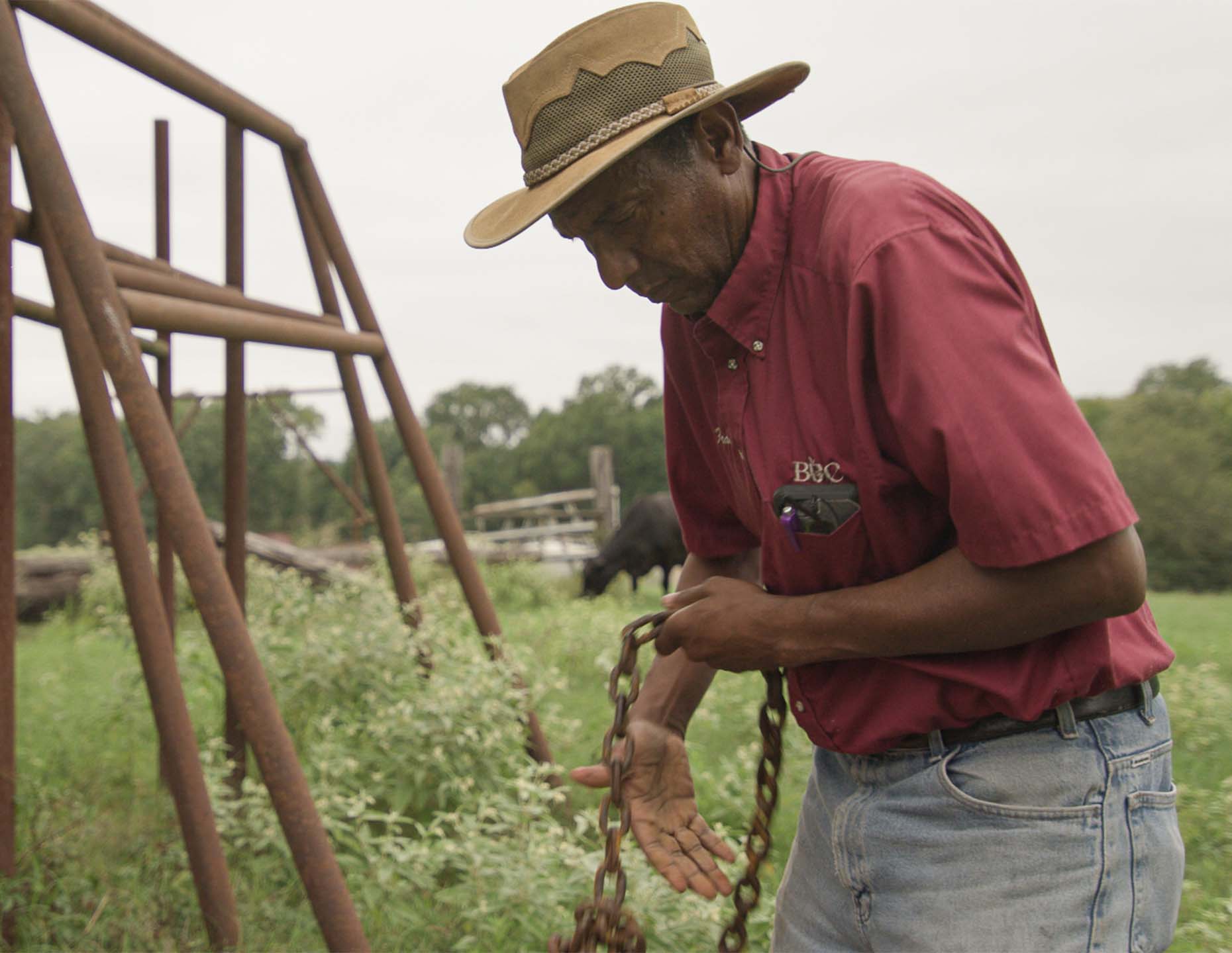 Francis Matlock holds chains while caring for the pasture. September 2020