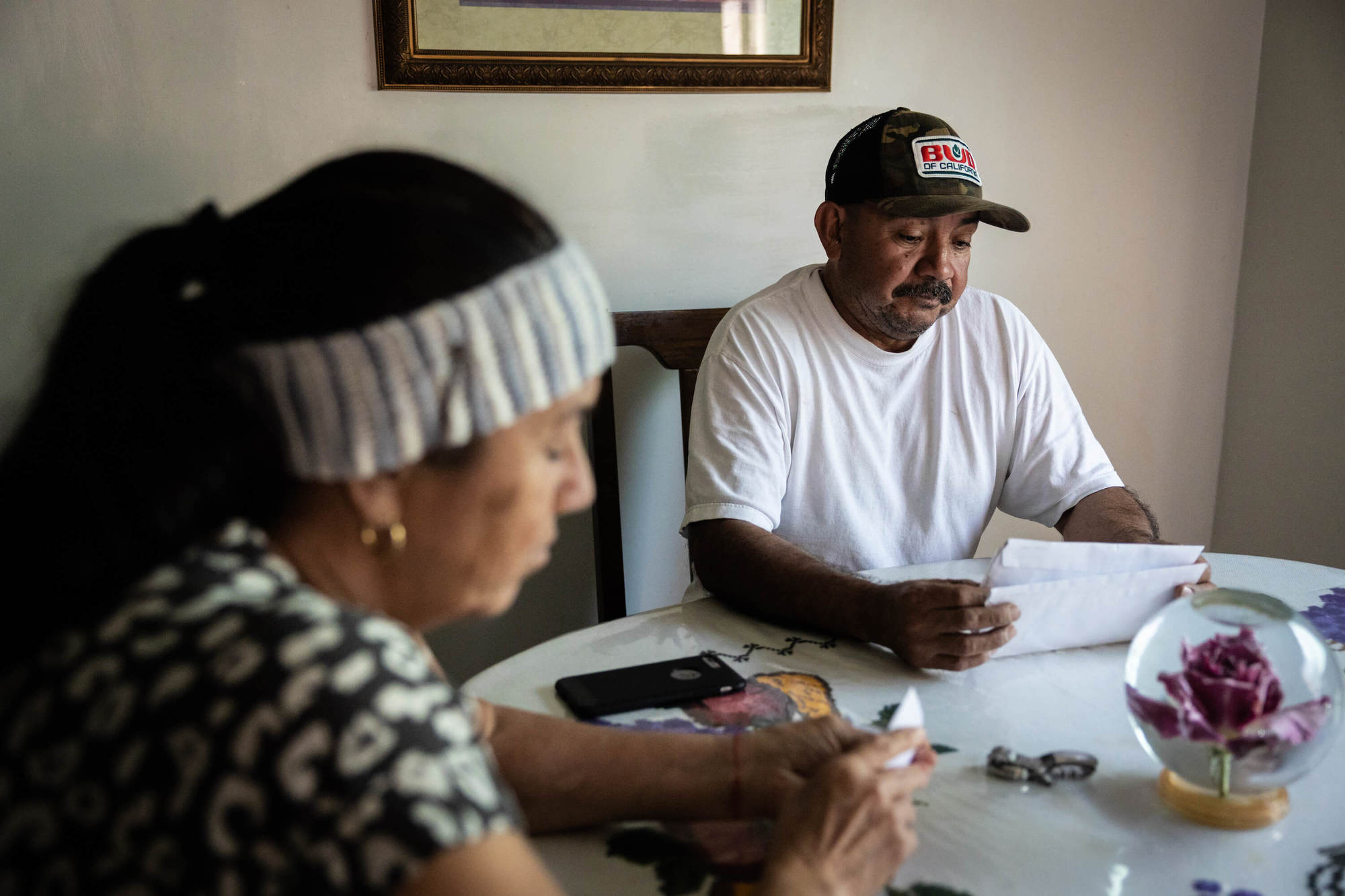 Nicanor Guillen and Angelica Guillen read mail at their kitchen table in their home in Fuller Acres. The Spanish-speaking couple received a letter in English about the water contamination.