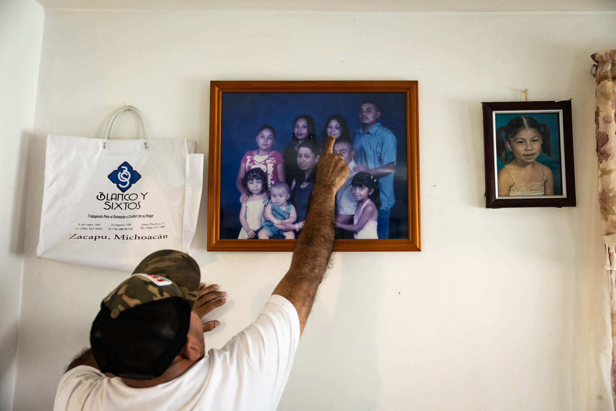 Nicanor Guillen points out his daughter Lupe in a family photo. Lupe had cancer as a child, a fact that Guillen suspects may be related to the contaminant present in the community’s water.