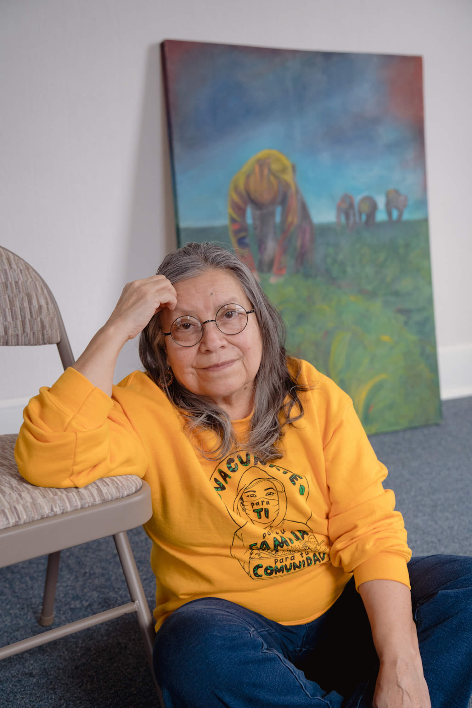 Rosalinda Guillén, a farmworker advocate, community organizer and founder of Community-to-Community Development, with one of her brother Miguel’s paintings at the C2C office in Bellingham, Washington. February 2022