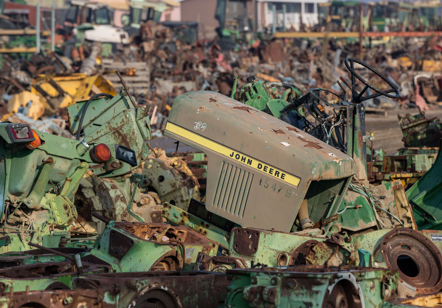 A junkyard showing an old broken John Deere tractor. March 2022