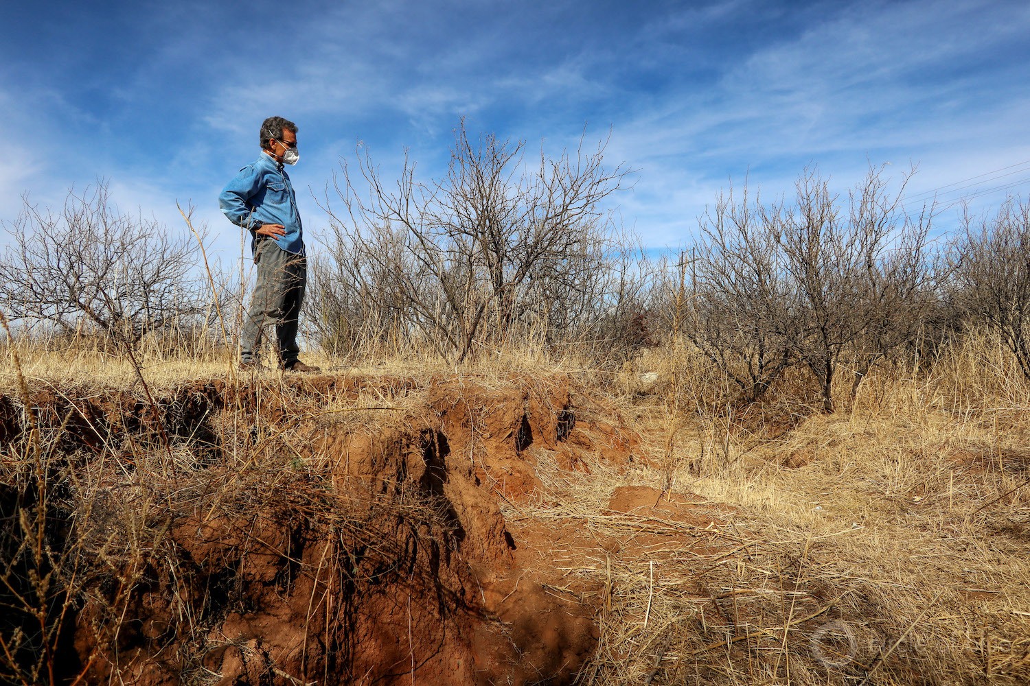 Steve Kiesel surveys a fissure, caused by gr0undwater pumping and land subsidence, that opened close to his home in Cochise County.
