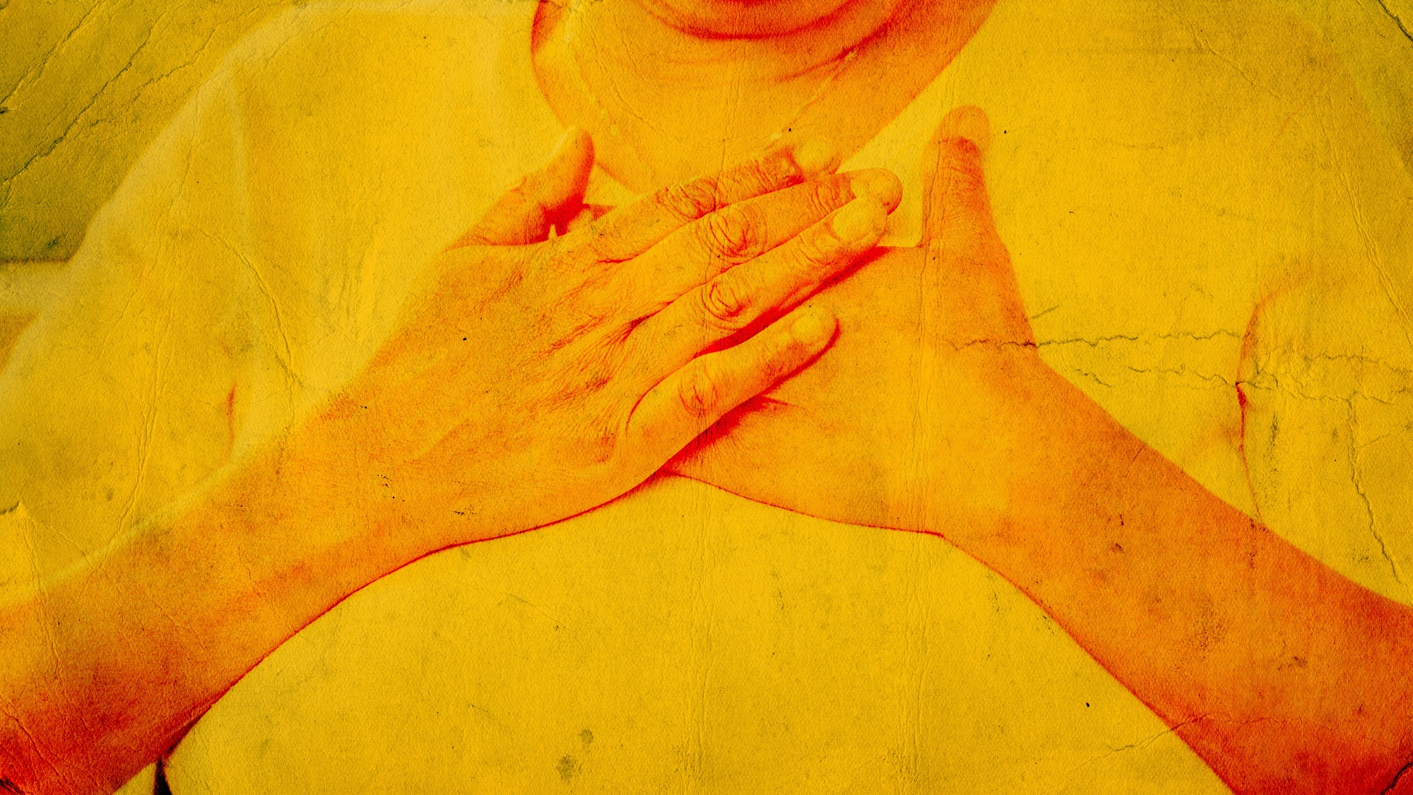 Hands crossed placed on chest with yellow paper treatment. March 2022