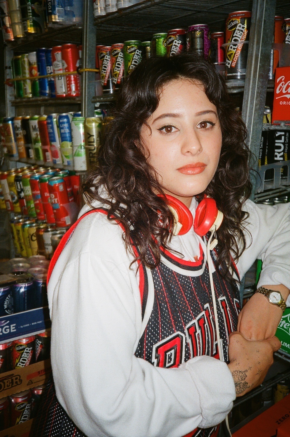 Portrait of Ariana Diaz in front of fridge full of drinks. April 2022