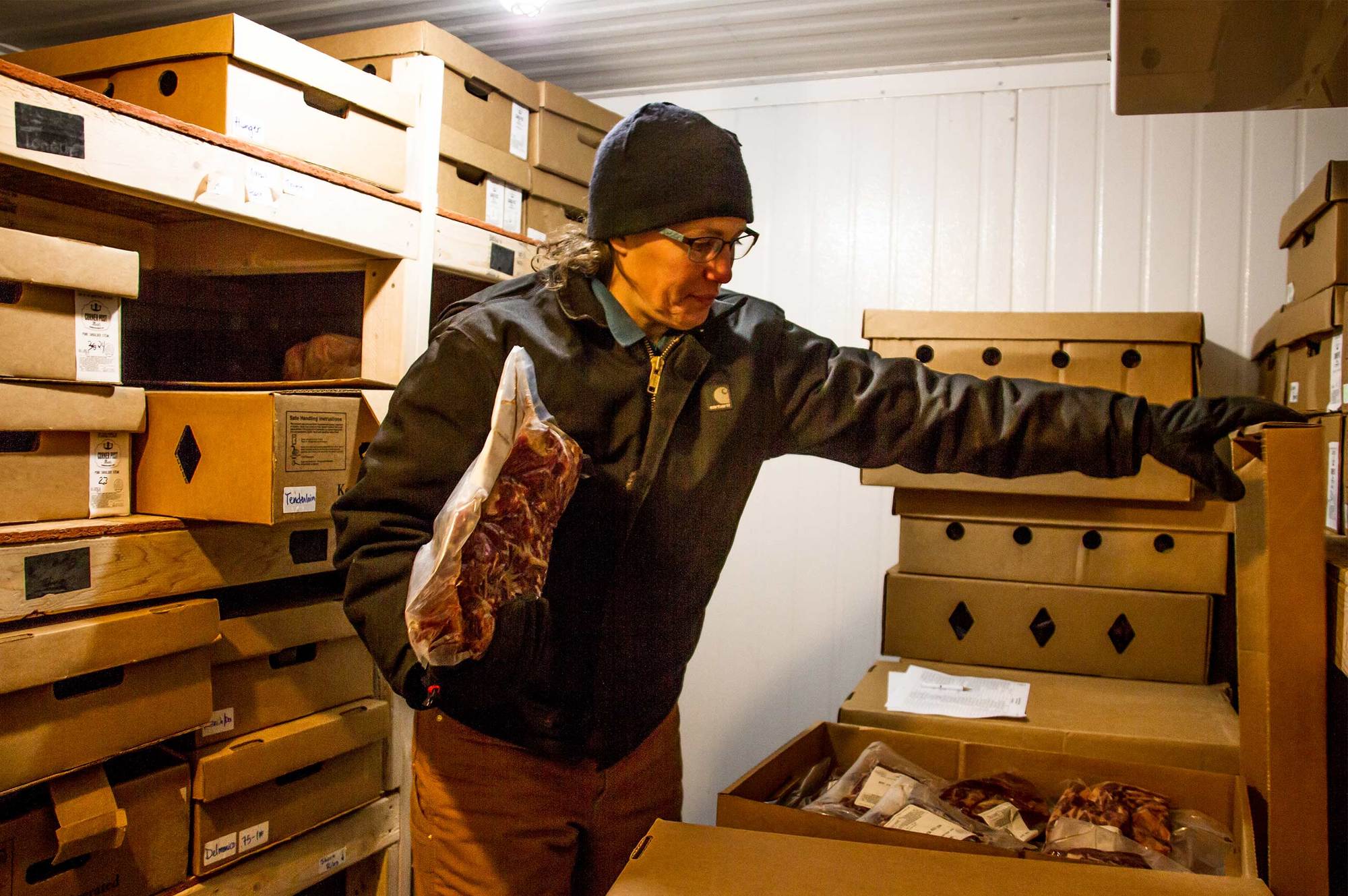 Larrew packs Audubon-certified meat inside Corner Post Meats' walk-in freezer.